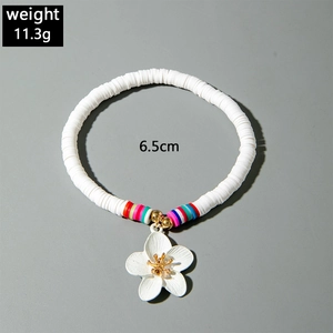 Detail of colorful resin bead bracelet featuring a white flower charm and elastic design