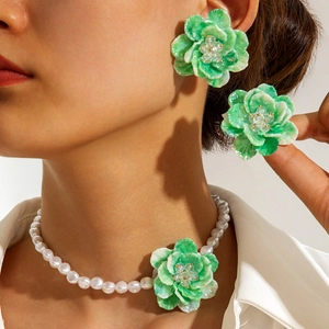 Sweet green floral stud earrings and pearl necklace jewelry set worn by a female model