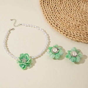 Detail showing resin flower earrings with clip-on backs and matching pearl necklace