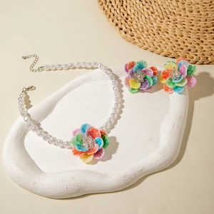Close-up of sweet layered flower jewelry set with resin pearl necklace and matching earrings
