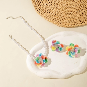 Close-up of colorful floral jewelry set with resin pearl necklace and matching earrings