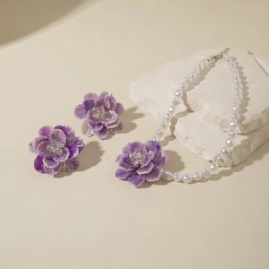 Detailed view of 3D purple flower pendant and matching earrings with white pearls