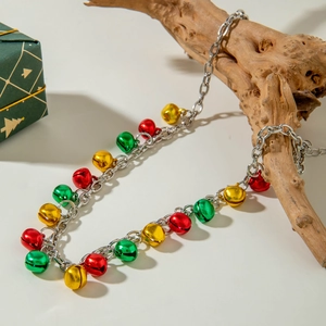 Détail du collier de Noël avec cloches colorées posé sur un support en bois naturel