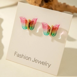 Macro view of gradient butterfly studs with cubic zirconia on white jewelry card