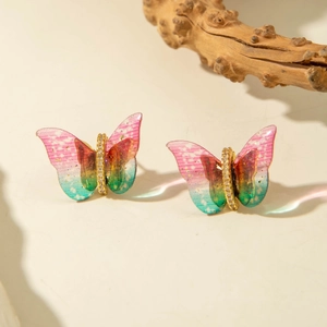 Close-up of butterfly stud earrings with colorful gradient wings and zircon accents