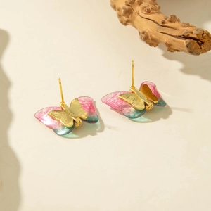 Detail of creative butterfly stud earrings featuring pink and cyan gradient resin wings