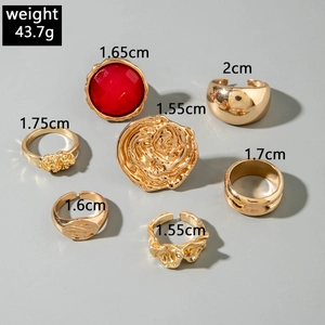 7-piece gold-plated liquid metal ring set with red gemstone and textured lava details