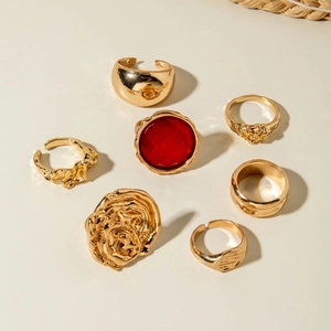 7-piece gold vintage ring set featuring a large red gemstone and liquid metal textures