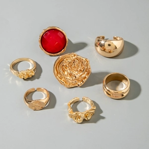 Detail of 7-piece gold ring set featuring a large red gemstone and 3D rose flower design