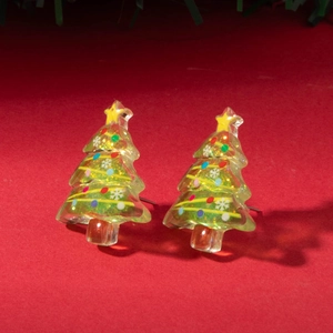 Detail of resin Christmas tree earrings with colorful flakes on red holiday background