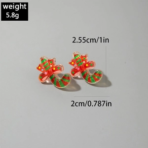 Detailed view of candy cane earrings with red bow and gold glitter on grey background