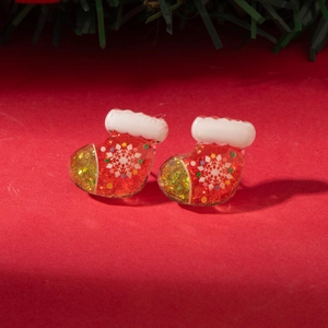 Detailed view of red Christmas stocking earrings with glitter and snowflake patterns