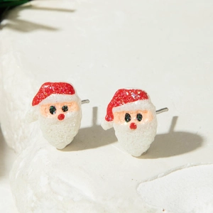 Macro shot of resin Santa Claus stud earrings with festive red and white glitter details