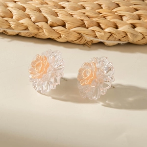 Detail view of 3D floral stud earrings with frosted petals and pink glitter center