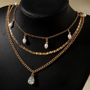 Elegante collana a strati dorata con perle a goccia e pendente in cristallo su modello