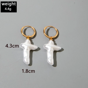 Détail de boucles d'oreilles créoles dorées avec croix en perle, taille 4,3cm et poids 4,4g