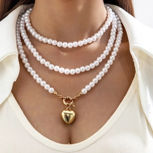 Collar de perlas blancas de varias capas con colgante de corazón dorado en modelo
