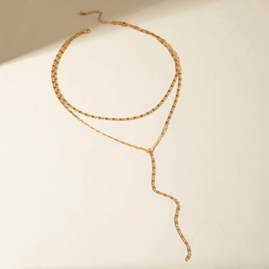 Detail of layered gold Y-necklace featuring delicate flat chains and a minimalist tassel