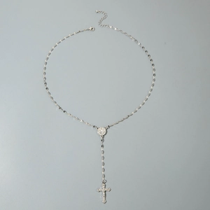 Detail of silver rosary necklace featuring a crucifix pendant and religious medal