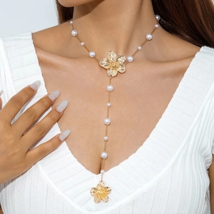 Elegante goldene Blumen-Y-Halskette mit Perlen und Blumenanhängern an einem Modell