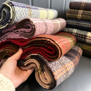Close-up of colorful thick plaid scarves showing soft texture and high-density fabric