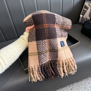 Close-up of thick plaid scarf featuring large brown checks and soft tassel edges