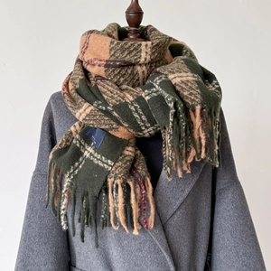 Close-up of thick plaid Christmas scarf with classic tassels on a grey wool coat