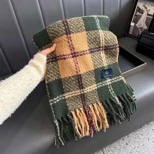 Close-up of thick plaid scarf featuring multicolor knit texture and long fringe tassels