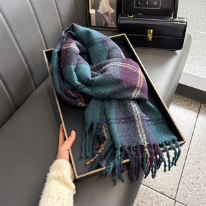 Detail of a thick plaid scarf with tassels, featuring deep purple and green patterns