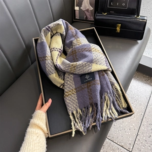 Detail of soft purple and beige plaid scarf with fringed edges and brand label on a tray