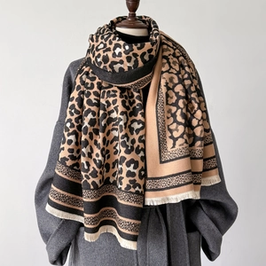 Winter leopard print scarf with white fringe and black stripes on a grey coat