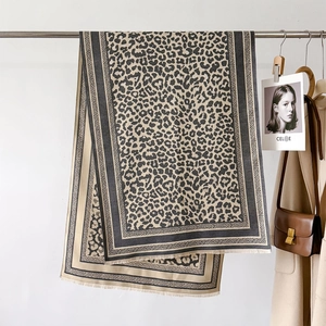 Thick leopard print cashmere-style scarf with tassel trim on a minimalist steel hanger