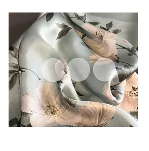 Dettaglio ravvicinato di foulard in seta azzurra con stampa floreale e finitura satin