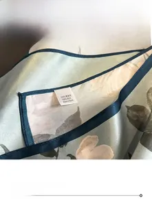 Dettaglio di un foulard in seta a fiori con cuciture fini e trama di alta qualità