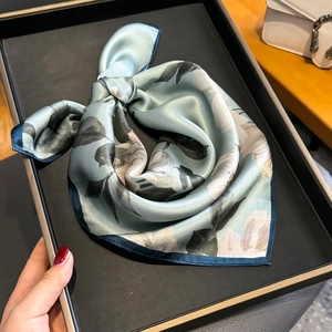 Elegante foulard in seta con motivi floreali azzurri e bordi arrotolati blu scuro
