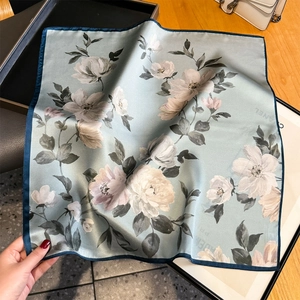 Sciarpa in seta azzurra con stampa floreale e bordi blu scuro con drappeggio elegante
