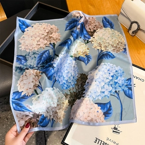 Floral silk square scarf with hydrangea print on wooden table with elegant accessories