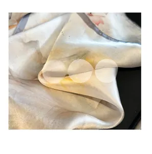 Detail of floral silk scarf showing soft fabric texture and elegant ink painting print
