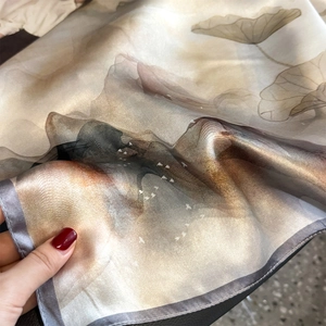 Elegant silk scarf with lotus and bird prints in warm brown gradient tones