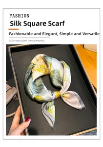 Detailed view of a luxury silk scarf with floral print folded on a black tray