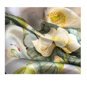 Close-up of silk scarf fabric showing lotus print and smooth satin texture details