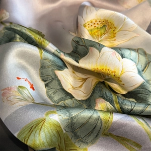 Elegant silk scarf featuring lotus and koi fish print with smooth satin luster and texture