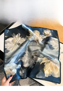 Gros plan d'un foulard en soie vintage avec fleurs jaunes sur fond bleu profond