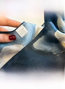 Gros plan des bords finement cousus et de la texture du foulard en soie de mûrier à 100%
