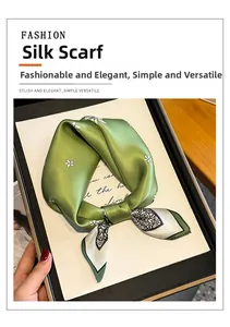 Detail of elegant green silk square scarf with floral pattern on display tray