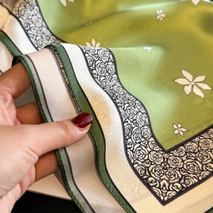Elegant green floral silk square scarf with glossy satin finish and delicate flower patterns