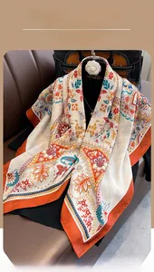 Close-up of lightweight vintage paisley shawl with orange borders on a leather sofa