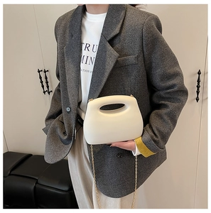 Chic cream acrylic box bag with cut-out handle and gold chain strap on model