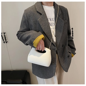 Detail of white acrylic box bag with golden chain strap and integrated handle