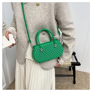 Detalle de bolso acolchado verde brillante con perlas decorativas y hebilla plateada